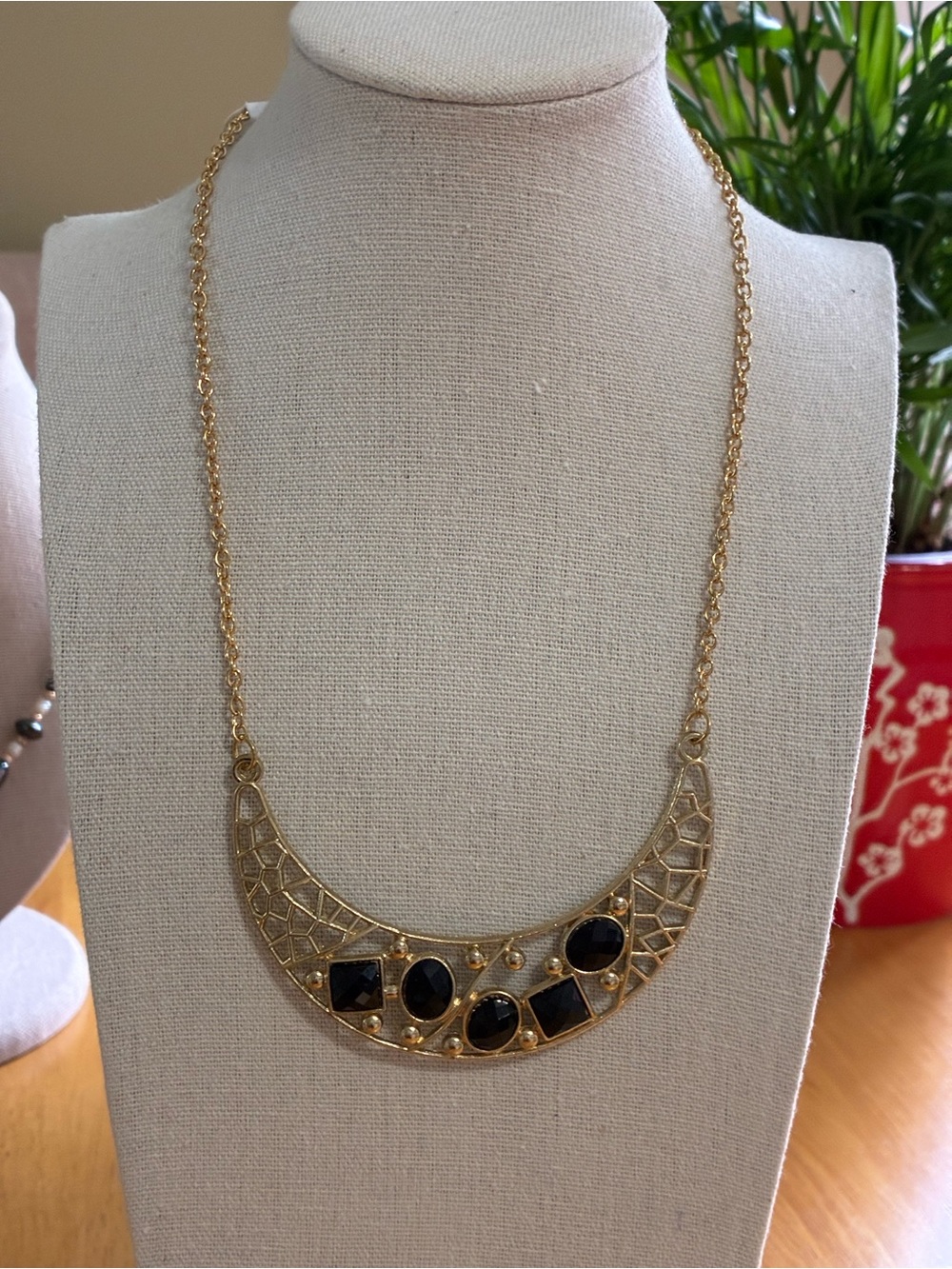 Gold-Tone Crescent Necklace with Black Stone Accents.